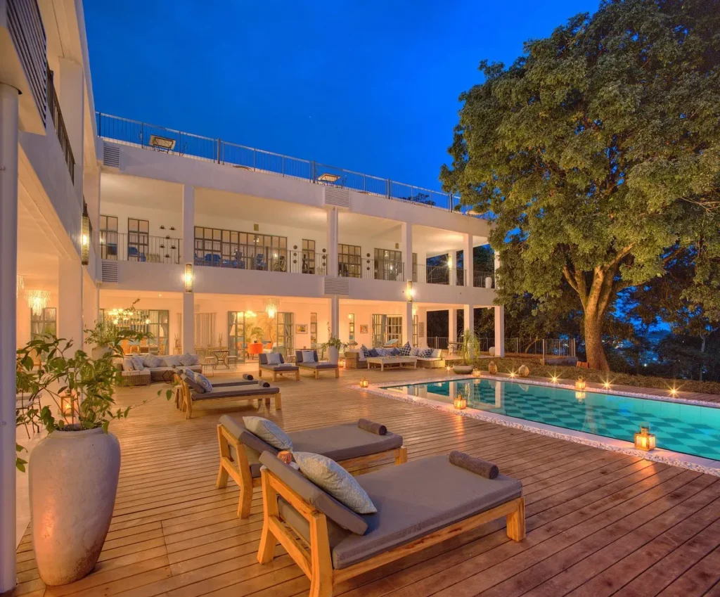 Luxury safari lodge with swimming pool, spacious wooden deck and comfortable lounge areas representing high-end accommodation in Uganda