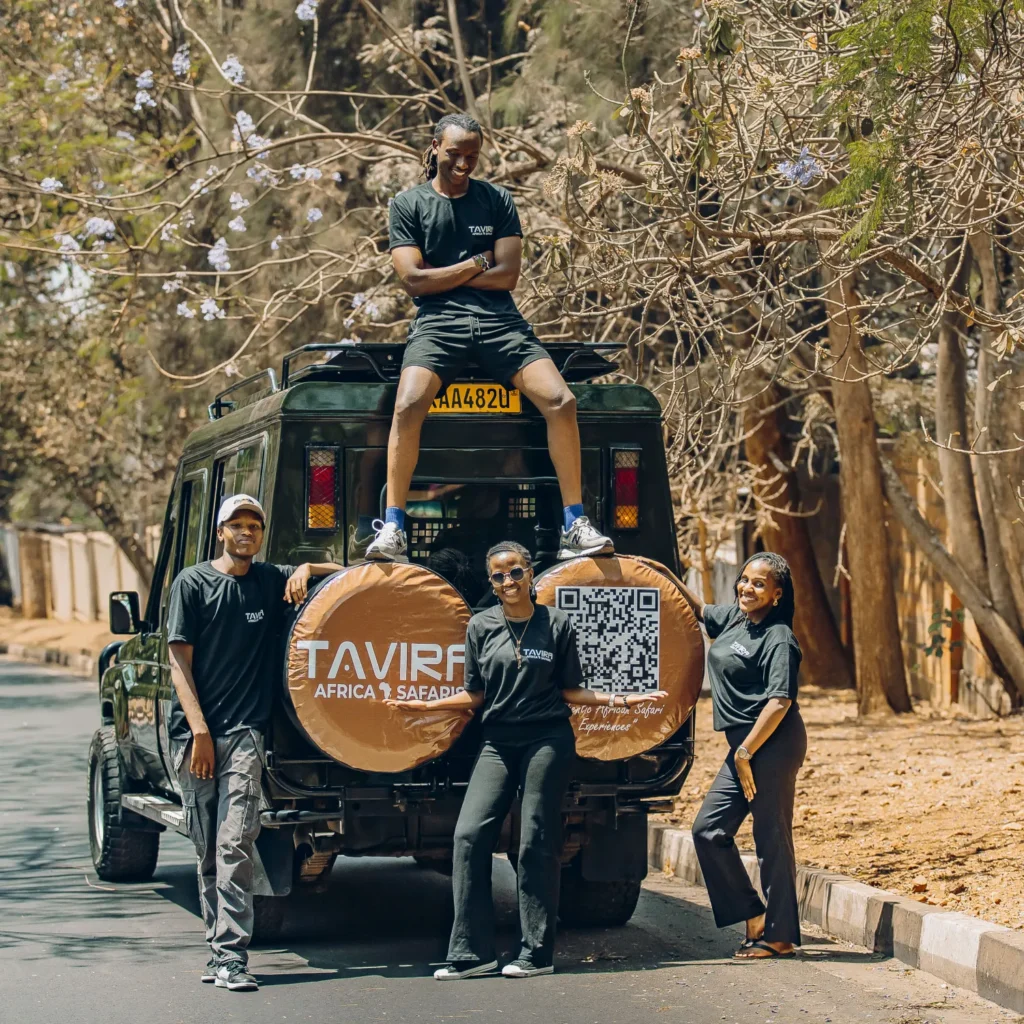 The Tavira Africa Safaris team beside a branded safari vehicle
